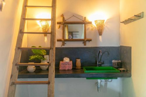 a bathroom with a sink and a wooden ladder at Pousada Spa Oasis in Caraíva