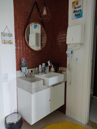 a bathroom with a white sink and a mirror at Golden Lake Apart-Hotel in Arraial do Cabo