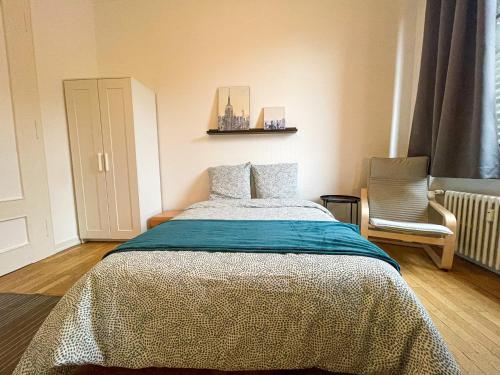 a bedroom with a bed and a chair at Chambres privées -Private room- dans un spacieux appartement - 100m2 centre proche gare in Mulhouse
