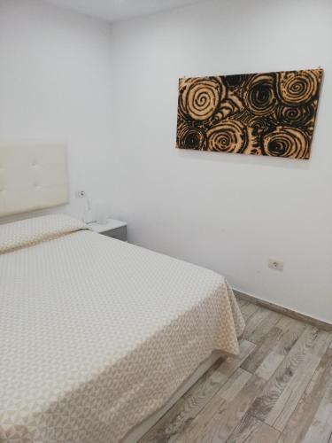 una camera da letto con un letto e un dipinto sul muro di Casa Gianluca ad Adeje
