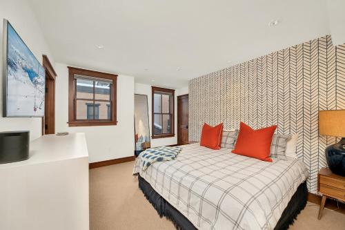 a bedroom with a bed with two orange pillows at Ballard 203 North - Luxury Condo w/ Postcard Views in Telluride