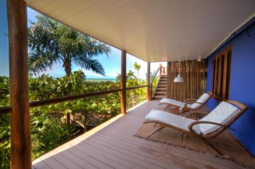 a porch with chairs and a view of the ocean at Pousada El Gordo in Trancoso