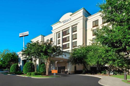 Sonesta Select Nashville Airport Suites في ناشفيل: فندق ابيض عليه لافته على الواجهه