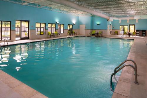 Sonesta Select Nashville Airport Suites في ناشفيل: مسبح كبير مع ماء أزرق في مبنى