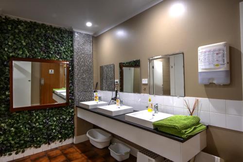 a bathroom with two sinks and two mirrors at KI Dragonfly Guesthouse in Kingscote
