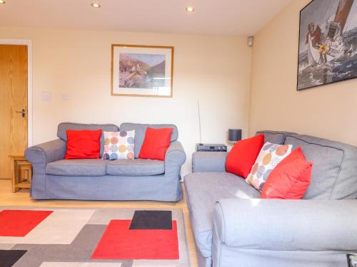 a living room with two couches and a rug at Taliesin in Porthmadog