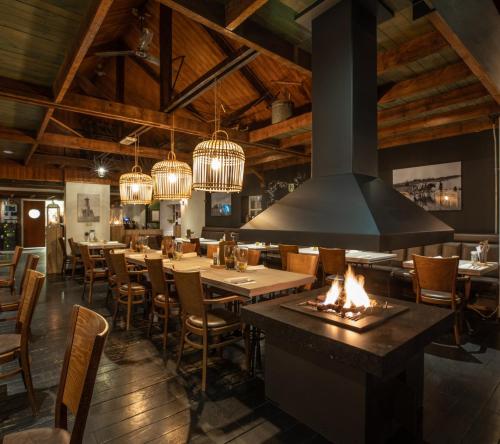 a restaurant with tables and chairs and chandeliers at Perfect get away - Cosy Cabin in the Woods in Diessen