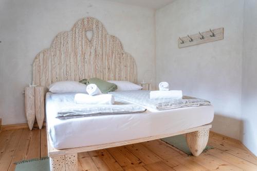 a white bed with a wooden headboard in a room at Country House Trata in Kranjska Gora