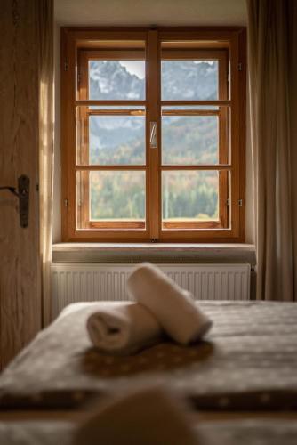 a window in a bedroom with a towel on a bed at Country House Trata in Kranjska Gora