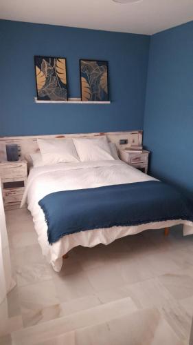 um quarto azul com uma cama com uma parede azul em Casa Flamenca em Castilleja de la Cuesta