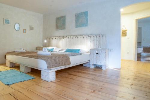 a bedroom with a large bed and a wooden floor at Country House Trata in Kranjska Gora