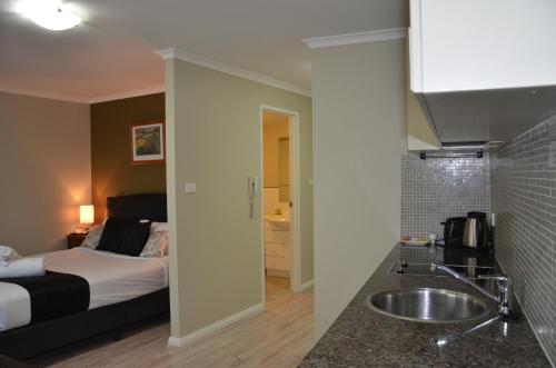 a bathroom with a bed and a sink in a room at Napoleon On Kent in Sydney