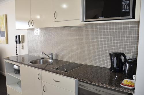 a kitchen counter with a sink and a microwave at Napoleon On Kent in Sydney