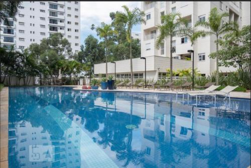 een leeg zwembad met gebouwen op de achtergrond bij Duplex Impression Morumbi in Sao Paulo
