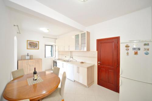 a kitchen with a wooden table and a wooden door at Sofija Apartment in Kotor