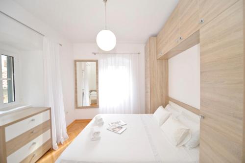a bedroom with a white bed and a window at Sofija Apartment in Kotor
