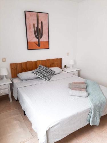 a bedroom with two beds and a painting on the wall at Tabaiba apartment in Corralejo
