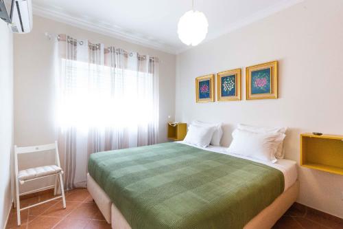 - une chambre avec un grand lit et une fenêtre dans l'établissement Villa Marquez Apartments, à Vila Real de Santo António