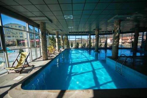 a large swimming pool with blue water in a building at Apartman MM , Banja Luka, Wi-Fi free,parking free in Banja Luka