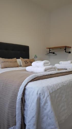 a bed with white towels on top of it at Patagonia Apart Dpto 3 in Paraná