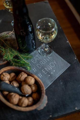 a bowl of nuts and a glass of wine on a table at Country House Trata in Kranjska Gora