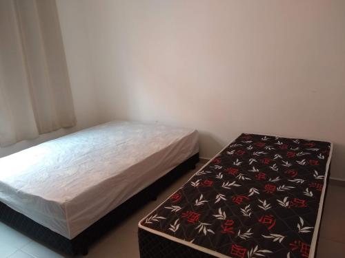 a small bedroom with a bed and a foot stool at Casa em Villagio em Boracéia próximo a praia. in Bertioga