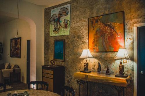 a room with a table and two lamps on a wall at Casa Del Prado in Mérida