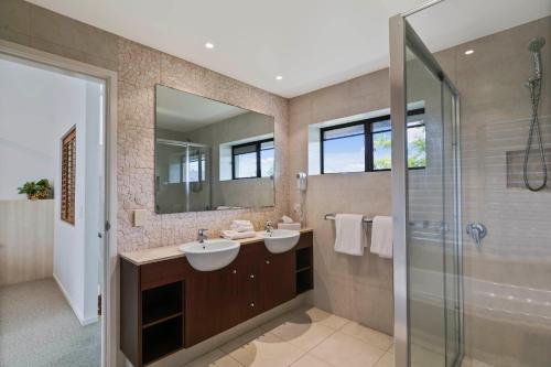 a bathroom with two sinks and a shower at Culgoa Point Beach Resort in Noosa Heads