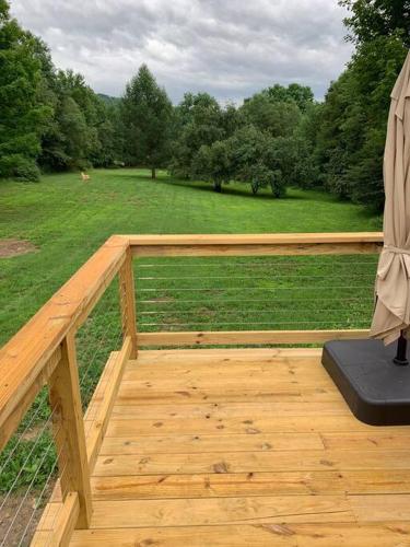a wooden deck with a view of a field at Harpersfield House /North West Catskills + sauna in Jefferson