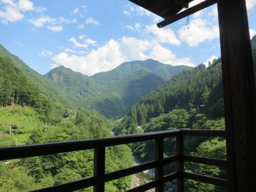 a view from the balcony of a mountain valley at Guesthouse Nishiki in Chichibu