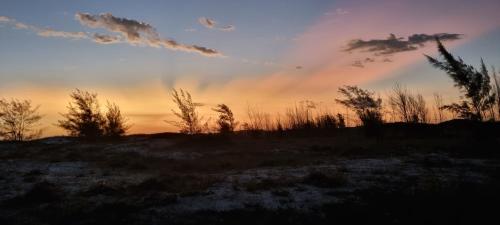 a sunset in a field with a rainbow in the sky at Apart-Hotel Golden Lake 2 in Arraial do Cabo