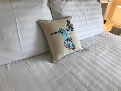 a pillow with a blue bird on a bed at Ryan's River Lodge B&B in Cong