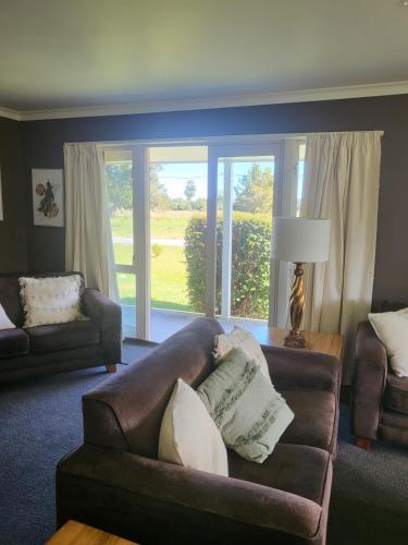 a living room with a couch and a window at Misty Peaks Guesthouse in Fox Glacier