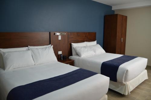 Dos camas en una habitación de hotel contigua en Hotel San Agustin Plaza, en Latacunga