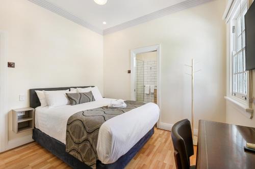 a small bedroom with a bed and a table at Canungra Hotel in Canungra