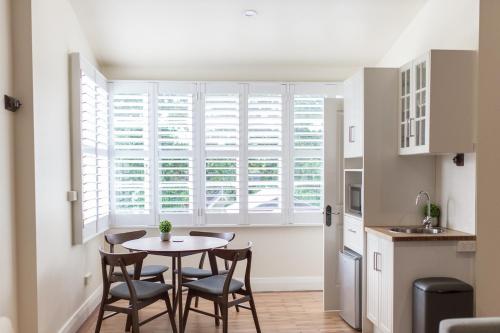a kitchen with a table and chairs and a window at Canungra Hotel in Canungra