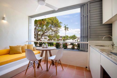 a kitchen with a table and chairs and a large window at Club Tropical Resort - Newly renovated Studio Apartments in Port Douglas