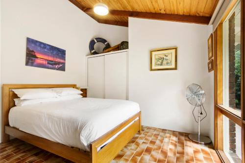 een slaapkamer met een bed en een ventilator bij Aruma in Metung