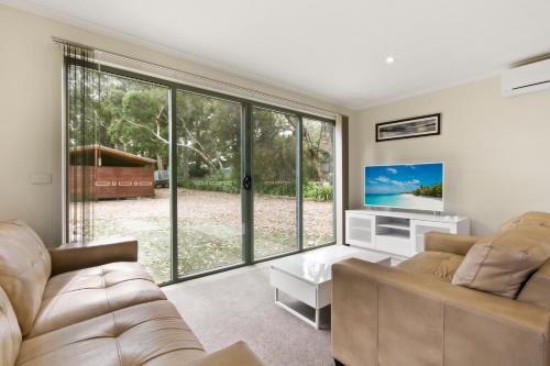 a living room with a couch and a large window at Aruma in Metung
