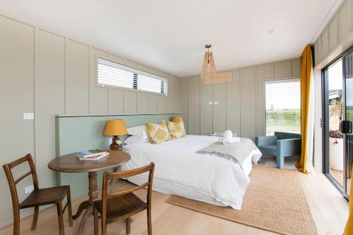 a bedroom with a bed and a table and a chair at Matawhero Wines in Gisborne
