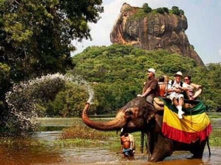 a group of people riding an elephant in the water at Hidden Lake Cottages Sigiriya in Sigiriya