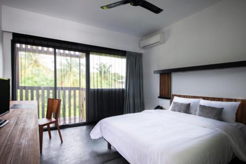 a bedroom with a large white bed and a window at Pages Rooms Hotel in Siem Reap