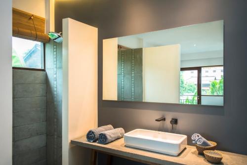 a bathroom with a sink and a mirror at Pages Rooms Hotel in Siem Reap