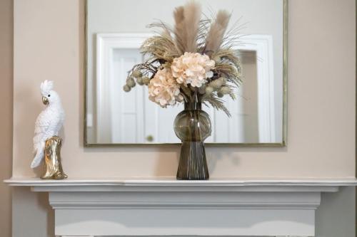 a vase with flowers on a mantle in front of a mirror at Mount Gambier Hotel in Mount Gambier