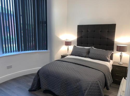 a bedroom with a large bed and two lamps at Albert Hottub & Jacuzzi Apartments in Blackpool