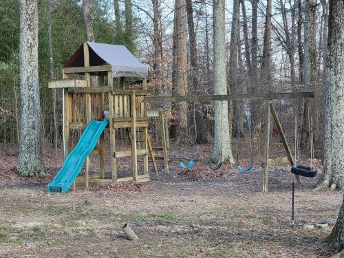 a tree house with a slide and swings at Just Breathe in Dandridge