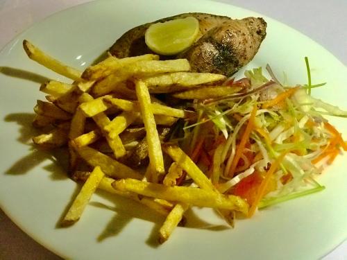 a plate of food with french fries and a salad at Ashansa Lagoon Resort in Tangalle