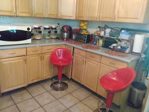 a kitchen with two red stools in a kitchen at Quiet and cozy bedroom with a warm lounging area and shared spaces WE HAVE A CAT in Cambridge