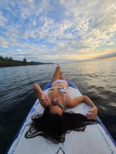 a woman laying on a paddle board in the water at Kenting Ocean World Diving II in Hengchun