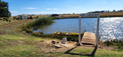 a sign that says pit station next to a lake at New Horizons Farm Stay in Smeaton